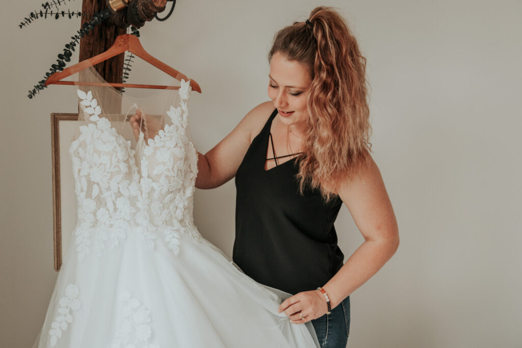 Wedding planner professionnelle préparant la robe de mariée avant le jour J